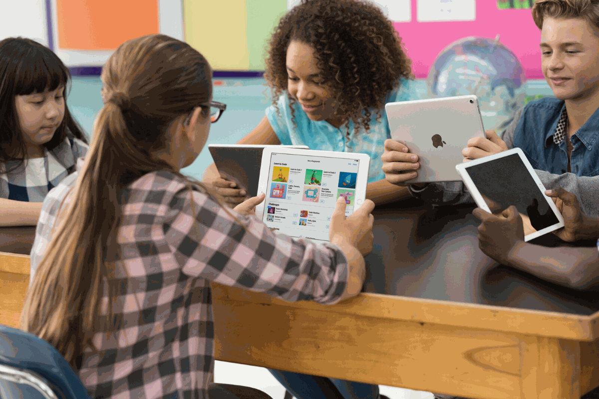 Students using Apple devices in a classroom for educational purposes